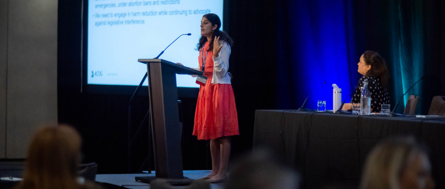 Dr. Nisha Verma speaking at a podium