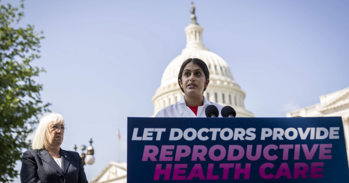 Dr. Nisha Verma speaking in front of the United States Capitol building with a sign reading "Let Doctors Provide Reproductive Health Care"
